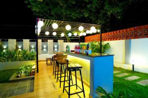 - un bar avec tabourets dans un jardin la nuit dans l'établissement Tiram Villa, à Visakhapatnam