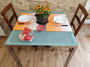 un tavolo blu con un vaso di fiori sopra di Jolie Maison au coeur de Parma avec Parking privé inclusif a Parma