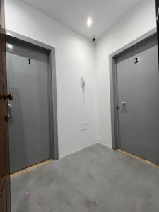 two doors in a room with a concrete floor at Erdis Home Nr 1 in Tirana