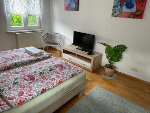 a bedroom with two beds and a flat screen tv at Ferienwohnung Emily in Friesenheim