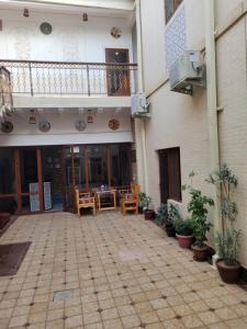 a courtyard of a building with chairs and a balcony at ESHONI PIR Boutique HOTEL in Bukhara