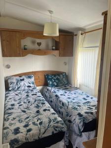 a small bedroom with two beds and a window at A7 caravan The Chase Ingoldmells in Ingoldmells