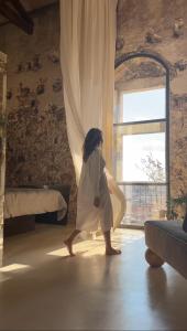 Una bambina che cammina in una stanza con una finestra di Special apartment in Noto a Noto