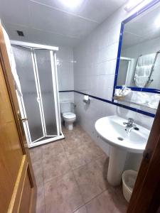 y baño con aseo, lavabo y ducha. en Hostal Restaurante El Surtidor, en Caspe