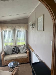 a living room with a couch and a window at A7 caravan The Chase Ingoldmells in Ingoldmells