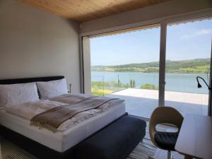 a bedroom with a bed and a large window at Lake View Apartments Beinwil am See (30 km to Lucerne) in Beinwil