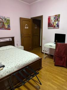 1 dormitorio con cama, escritorio y ordenador en La Maison Blanche, en Borghesiana 