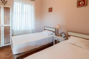 2 łóżka pojedyncze w pokoju z oknem w obiekcie Hotel Tsinandali Memories w mieście Tsinandali
