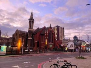a church with a tower and two bikes parked on a street at Hackney Guest Rooms in London