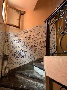 a staircase in a room with a patterned wall at Fatna's appartement in Safi