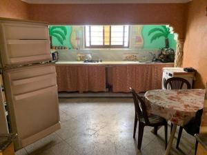 a kitchen with a table and a sink and a refrigerator at Fatna's appartement in Safi