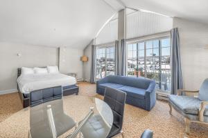 a hotel room with a bed and a couch at Le Bordeau à Saint-Sauveur in Saint-Sauveur-des-Monts