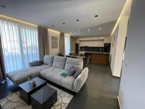 ein Wohnzimmer mit einem großen Sofa und einer Küche in der Unterkunft Villa Nika in Bibinje