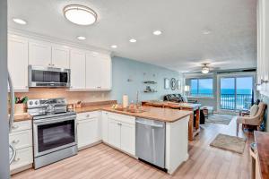 cocina con armarios blancos y vistas al océano en 306 Coral Sands, en Fernandina Beach