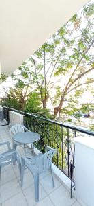 a patio with two chairs and a table and a balcony at Sunrise1 in Paralia Katerinis