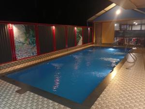 a large swimming pool with blue water at night at Galaxy villa in Wayanad