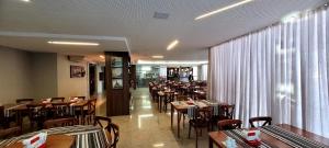a dining room with tables and chairs in a restaurant at IT's Hotel in Caratinga