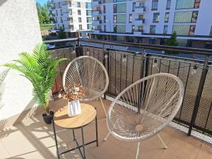 balkon z 2 krzesłami, stołem i wentylatorem w obiekcie Baśniowy Apartament w mieście Lublin