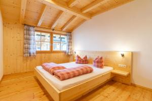 1 dormitorio con 1 cama en una casa de madera en Weberstube Weberhaus Zollhaus Zollstöckl, en Obertilliach