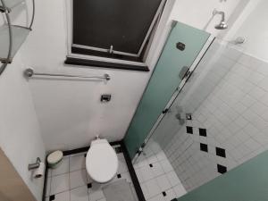 a small bathroom with a toilet and a shower at Leme in Rio de Janeiro