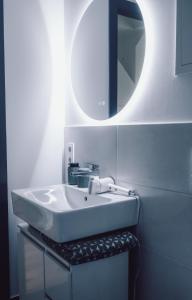 a bathroom with a white sink and a mirror at Suite 13 im Wald mit Balkon in Amberg