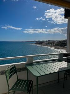 balcón con mesa, sillas y vistas al océano en Ocean Studio Maspalomas, en San Agustín