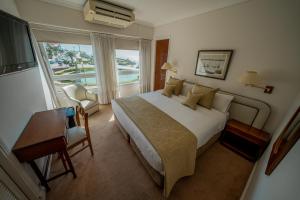 a bedroom with a large bed and a large window at Hotel Iruña in Mar del Plata