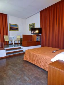una camera con letto, scrivania e tavolo di Bella Italia Palace Hotel a Novara