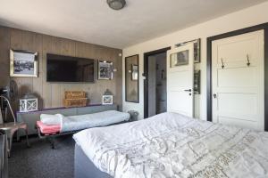 1 dormitorio con 1 cama y TV de pantalla plana en Beautiful house n.Amsterdam, suitable for families, en Hilversum
