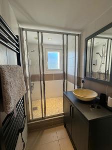 a bathroom with a sink and a glass shower at Maison Goxoki 