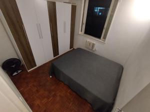 uma pequena cama num pequeno quarto com uma janela em Leme no Rio de Janeiro