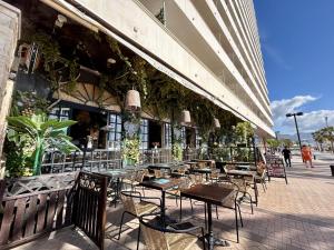 um restaurante com mesas e cadeiras fora de um edifício em Stella Maris Estrella del Mar Ecobeach Fuengirola em Fuengirola