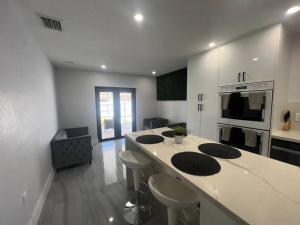 una cocina con una gran isla en una habitación en Stadium Chic Oasis: Modern Retreat in Miami close to Beaches en Miami Gardens