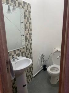 ein Badezimmer mit einem Waschbecken, einem WC und einem Spiegel in der Unterkunft Spacieux appartement 2 chambres 1 salon à 5 minute de l aéroport Marrakech Ménara in Marrakesch