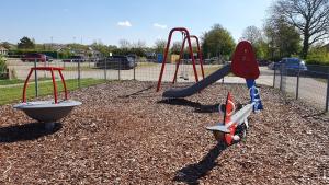 a playground with a slide and a swing at Luxe vakantiehuis met omheinde tuin voor hond en kinderen in Dirkshorn