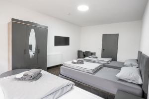 a room with three beds and a mirror at Duisburger Hostel in Duisburg