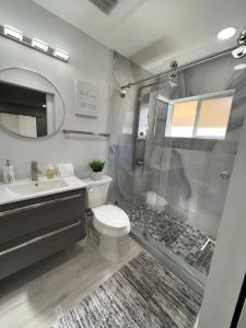 a bathroom with a shower and a toilet and a sink at Stadium Chic Oasis: Modern Retreat in Miami close to Beaches in Miami Gardens