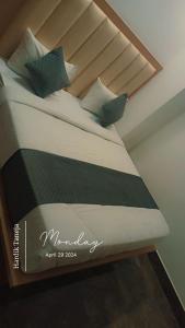 Una cama con almohadas verdes encima. en Hotel Sarovar Regenta, en Mathura