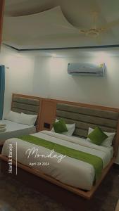 2 camas con almohadas verdes y blancas en una habitación en Hotel Sarovar Regenta, en Mathura