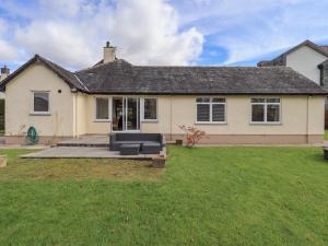 une maison avec une grande pelouse devant dans l'établissement Laal Field House, à Keswick