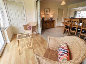 - un salon avec des chaises en osier et une table dans l'établissement Laal Field House, à Keswick