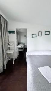 1 dormitorio con 2 camas, mesa y sillas en Femyli rooms, en Shekhvetili