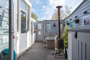 an outdoor patio with a grill and a barrel at Beautiful house n.Amsterdam, suitable for families in Hilversum