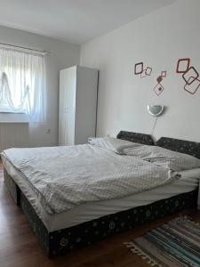 um quarto com uma cama num quarto branco em Györgyi Haus em Bük