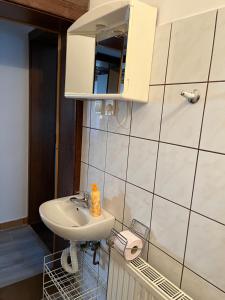 ein Bad mit einem Waschbecken und einem Spiegel in der Unterkunft Györgyi Haus in Bük