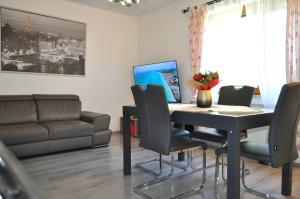 een woonkamer met een tafel met stoelen en een bank bij EG Das Familien-Apartment TOP 1 in Wenen