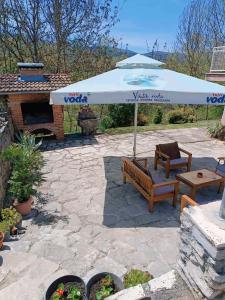 eine Terrasse mit einer Bank und einem Sonnenschirm in der Unterkunft Apartman Unac in Drvar