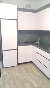 a kitchen with white cabinets and a counter top at AIRHOTEL in Codru
