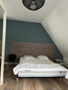 a bed in a bedroom with a blue wall at Villa de caractère à Saint- Malo 100m du Sillon in Saint Malo