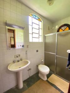 a bathroom with a sink and a toilet and a shower at Fazenda São Lourenço na Serra da Mantiqueira in Queimada